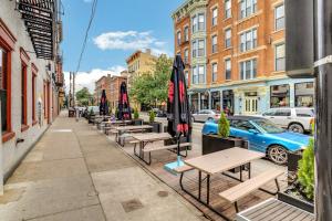 a row of tables and umbrellas on a sidewalk at Urban Paradise in OTR - Beautiful New Condo In Historic Building With Downtown Views! condo in Cincinnati
