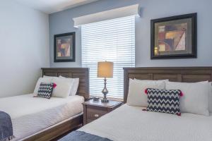 sypialnia z 2 łóżkami i oknem w obiekcie Shoreway Loop Unit 108 Condo w Orlando