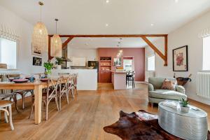 a kitchen and living room with a table and chairs at Owl Barn in Aston