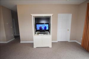 uma sala de estar com televisão num armário branco em 1414 Ironwood Condo em Myrtle Beach