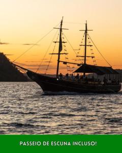 ein Boot im Wasser mit Sonnenuntergang im Hintergrund in der Unterkunft Pousada Piratas do Barro Branco in Pedregulho