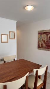 a dining room with a wooden table and chairs at Administración MAIPU 1C FI Depto Premium in Tandil