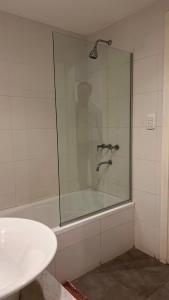 W łazience znajduje się szklana kabina prysznicowa i umywalka. w obiekcie Administración MAIPU 1C FI Depto Premium w mieście Tandil