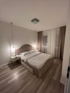 um quarto com uma cama grande e uma mesa lateral em Jacuzzi Home em Oradea