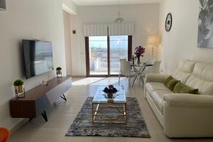 un soggiorno con un divano e un tavolo di Eleona's Royal Gardens By Yiota - Luxury 2 Bed Apartment in Exclusive Complex a Peyia Altre 31 foto