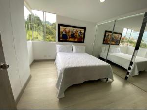 a bedroom with two beds and a mirror at Lujoso apartamento en envigado,con hermosa y exclusiva vista in Envigado