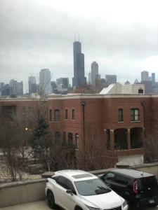 Winter Wonderland Retreat and Your Chicago Chill Getaway في شيكاغو: سيارة بيضاء متوقفة أمام مبنى من الطوب
