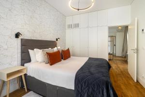 a bedroom with a large white bed with orange pillows at WHome | Ribeira 11 Design Apartment in Lisbon