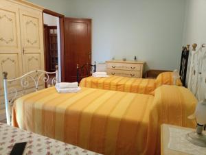 um quarto com 2 camas com lençóis amarelos em CasAda spazioso e luminoso appartamento em Tricase