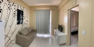 ein Wohnzimmer mit einem Sofa und einem TV in der Unterkunft Apartment Cumbuco Residence in Cumbuco