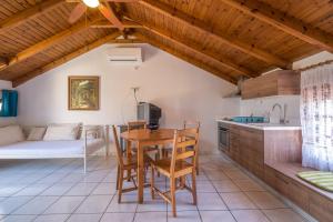 a kitchen with a table and chairs and a couch at Villa Emily in Syvota