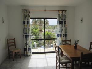 a dining room with a table and a large window at Villa Figueira in Figueira