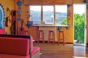 Habitación con bar con taburetes y ventana en Meiga Backpackers Hostel, en Santiago de Compostela