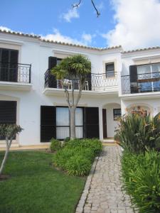 una casa blanca con una palmera en el patio en Villa Figueira, en Figueira