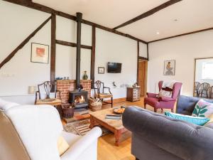 a living room with couches and a fireplace at Ivy House Barn in Eye