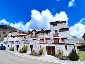 un gran edificio de piedra con un cielo azul en el fondo en Casa Balcón de Los Pirineos - Gavín Biescas, en Gavín