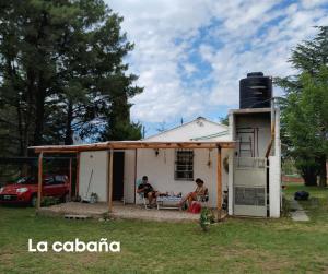 een paar mensen die buiten een huis zitten bij Cabaña Mateo in Cordoba
