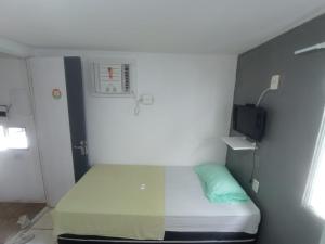 a small room with a bed and a tv at Casa Aeroporto Pousada in Recife