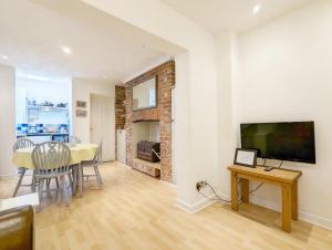 a living room with a dining room table and a television at Dolphin House, Emsworth in Emsworth