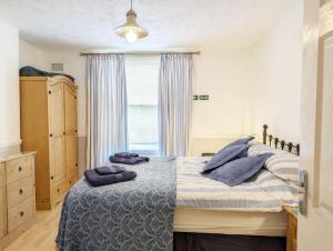 a bedroom with a bed with blue pillows on it at Dolphin House, Emsworth in Emsworth