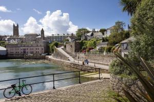 a bike parked next to a river in a city at Albert Apartment with free Gym in Penzance