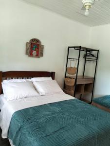 ein Schlafzimmer mit einem Bett mit einer grünen und weißen Decke in der Unterkunft Casa da Baronesa in Santa Maria Madalena