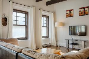ein Wohnzimmer mit Sofa und Fernseher in der Unterkunft Les Lofts St-Jo - Par Les Lofts Vieux-Québec in Québec + 5 Fotos