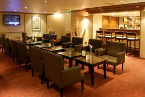 restauracja ze stołami i krzesłami oraz bar w obiekcie Hotel Conte w BuenosAires