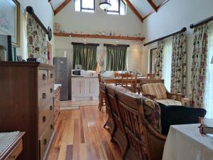 uma sala de estar com cadeiras e uma mesa e uma cozinha em Clarens Mountain Sage Cottage em Clarens