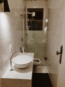 a bathroom with a white sink and a shower at Kitnet na Rua Sapucai in Belo Horizonte