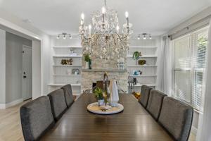 a dining room with a table and chairs and a chandelier at A Wave From It All in Largo