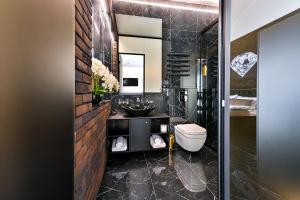 uma casa de banho preta com um lavatório e um WC em Diamond svečių namai em Kaunas