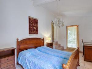 sypialnia z łóżkiem, biurkiem i żyrandolem w obiekcie Holiday Home Le Hameau des Launes - SIG110 by Interhome w mieście Signes