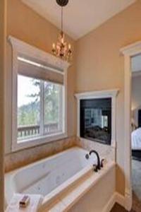 ein Bad mit einer Badewanne und einem Fenster in der Unterkunft Jacksonville Mountain Retreat with Pool and Hot Tub! in Jacksonville
