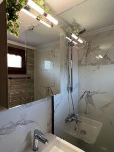 a bathroom with a tub and a sink and a shower at Lucid Dream Apt. Bozinis 2 in Psakoudia +10 photos