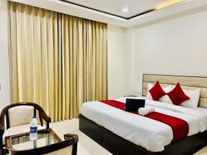 a bedroom with a bed with a laptop on it at "Hotel The Lycoris" Near Bus Stand ZIRAKPUR on AMBALA HIGHWAY in Zirakpur