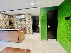 a lobby with a green wall and a reception desk at "Hotel The Lycoris" Near Bus Stand ZIRAKPUR on AMBALA HIGHWAY in Zirakpur