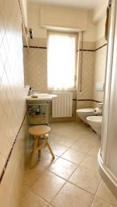 La salle de bains est pourvue d'un lavabo, de toilettes et d'une fenêtre. dans l'établissement Appartamento Corallo - WiFi, à Sanremo