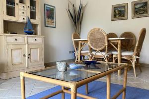 - un salon avec une table et des chaises en verre dans l'établissement Appartamento Corallo - WiFi, à Sanremo