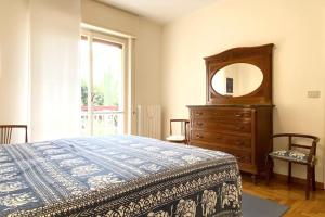 - une chambre avec un lit, une commode et un miroir dans l'établissement Appartamento Corallo - WiFi, à Sanremo