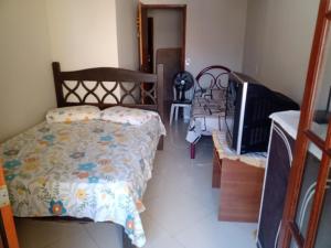 a bedroom with a bed with a flowered comforter at Meu Aconchego in Cabo Frio