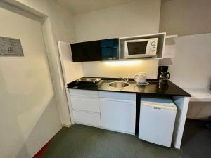 una pequeña cocina con fregadero y microondas en Modern Loft in Buenos Aires down town en Buenos Aires