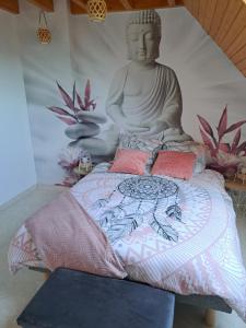 uma cama num quarto com uma estátua de Buda em Cottage Le Cabanon em Huisnes-sur-Mer