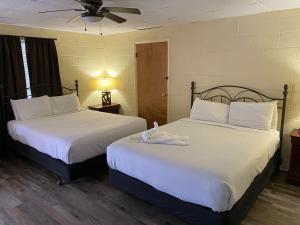 duas camas num quarto de hotel com lençóis brancos em JI7, A Queen Guest Room at the Joplin Inn at entrance to the resort Hotel Room em Mount Ida
