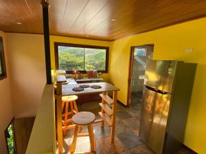 a small kitchen with a refrigerator and a table and stools at Indigo Container House in San Luis