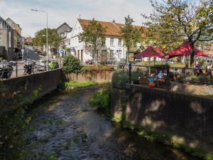 a river in a town with people sitting at tables at Feel at Home - Holiday Studio in Gulpen