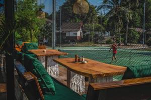 een man die tennist op een tennisbaan bij Arena Boutique Hotel Female only in Thongsala