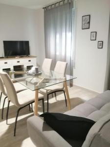 sala de estar con mesa de cristal y sillas blancas en CALDERON, en La Roda