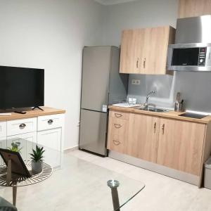 a kitchen with wooden cabinets and a stainless steel refrigerator at CALDERON in La Roda