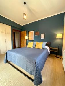 ein Schlafzimmer mit einem großen blauen Bett mit gelben Kissen in der Unterkunft Apollon Paian , Luxury Nature Relax in Lefkada Town